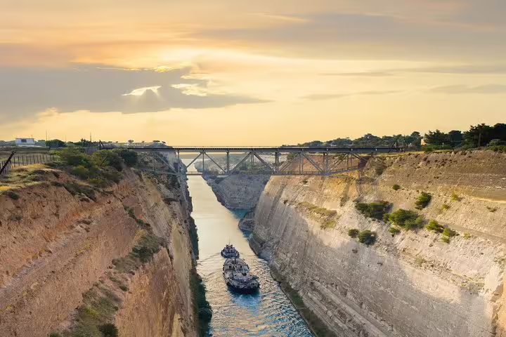 Sunset view over the Corinth Canal with a boat passing below, highlight of an Argolis private full day tour