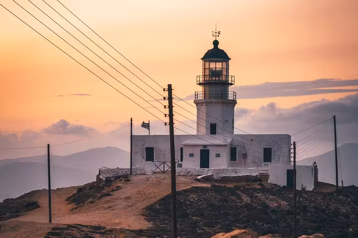 Sunset view of Armenistis Lighthouse on Mykonos coast, scenic highlight on a private town and countryside tour