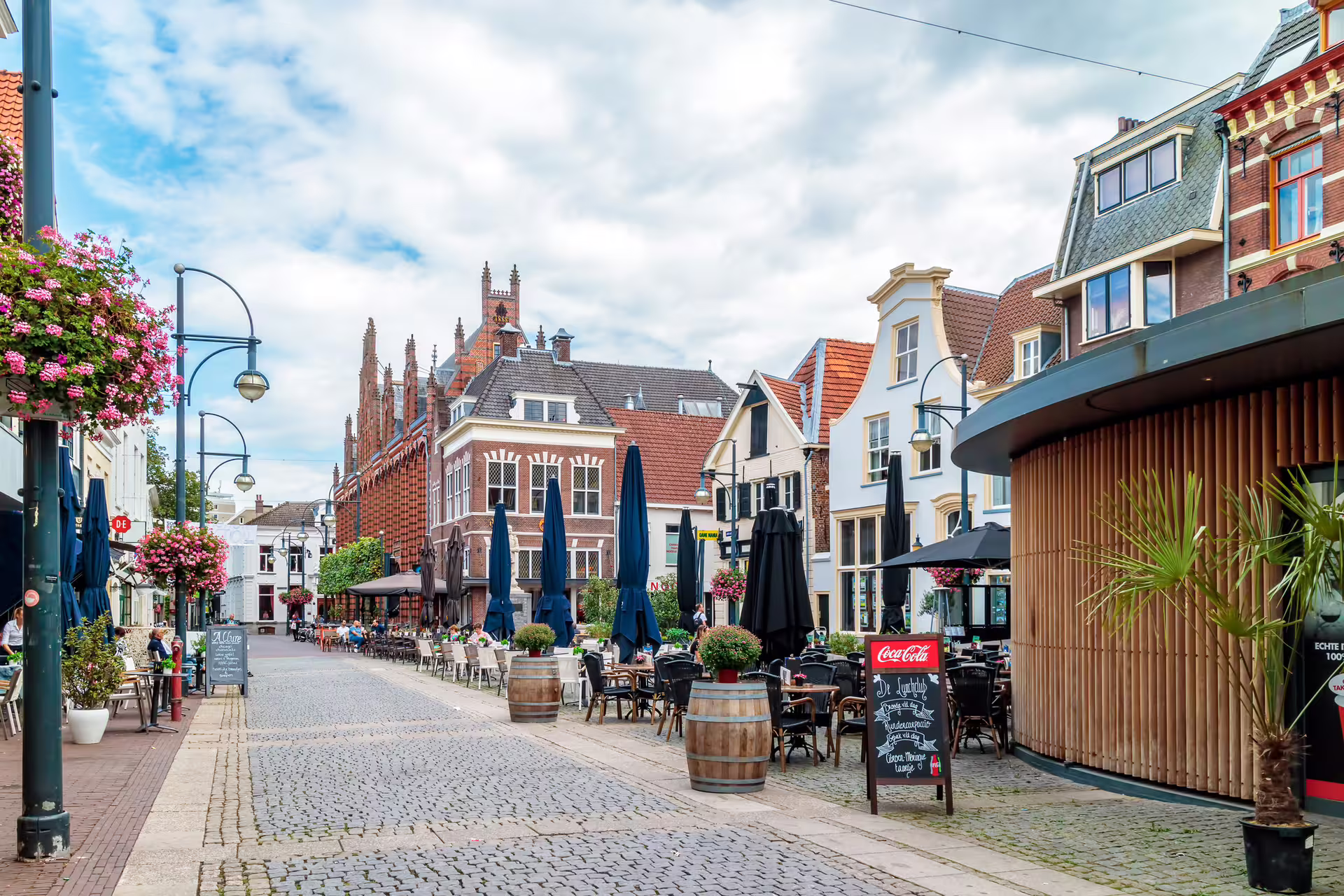 Cobbled Arnhem city center street lined with terrace cafés and historic facades, featured on 1-day audioguide walk