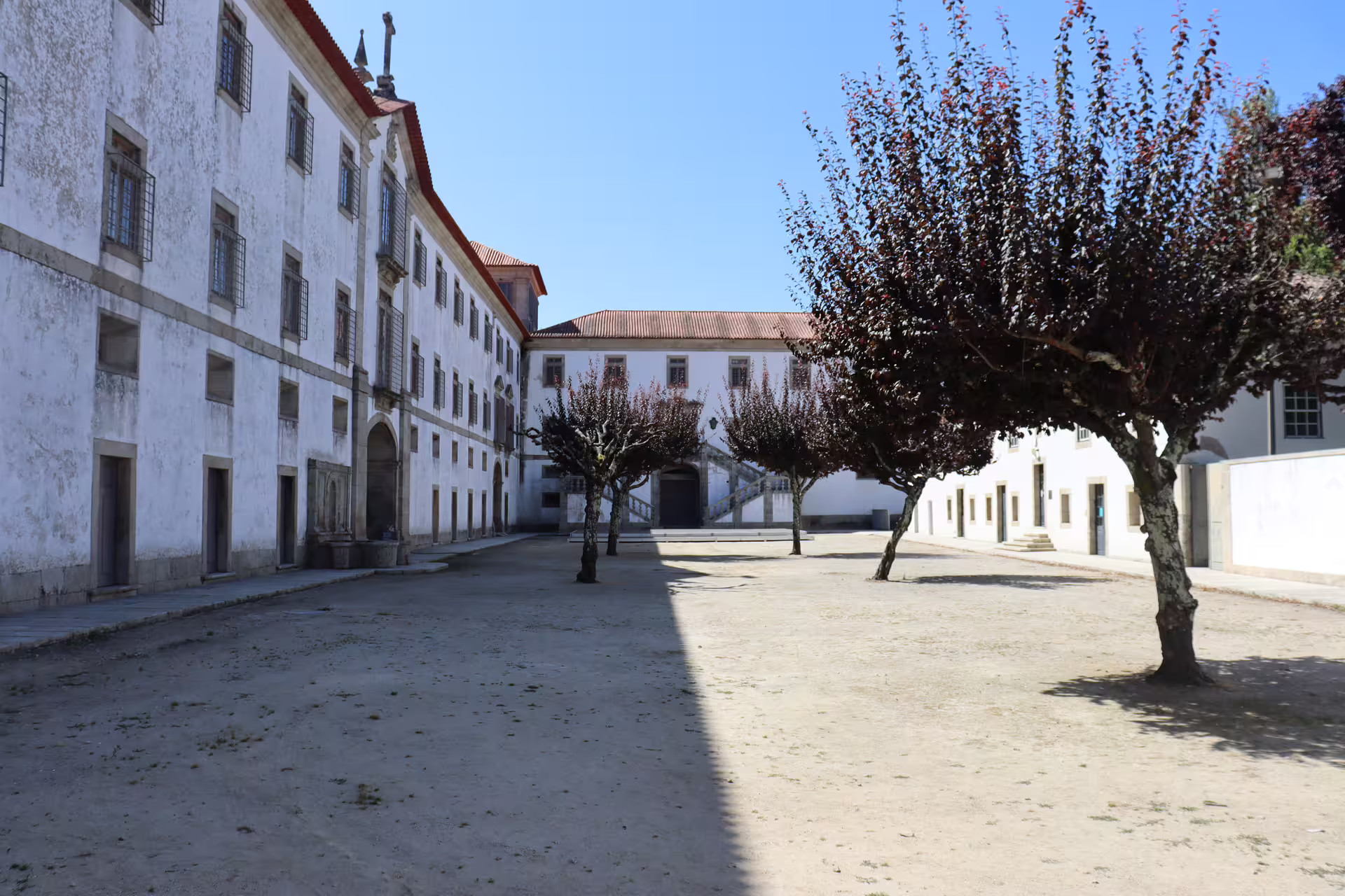 Historic Arouca Monastery courtyard with lush trees, ideal for starting a private tour to Arouca 516 Bridge and Paiva Walkways.