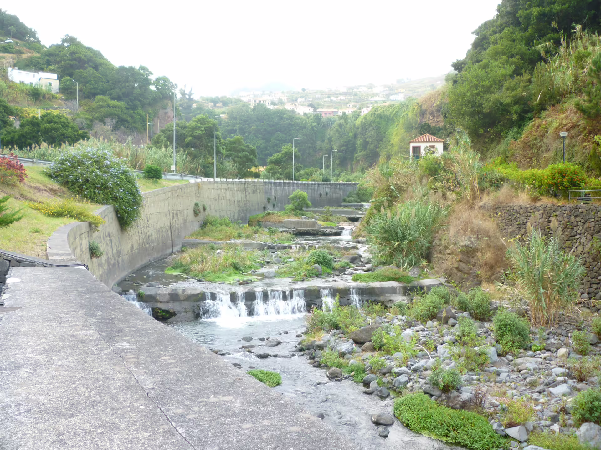Scenic view of a lush valley with cascading stream and surrounding greenery on the Around the Island Tour.