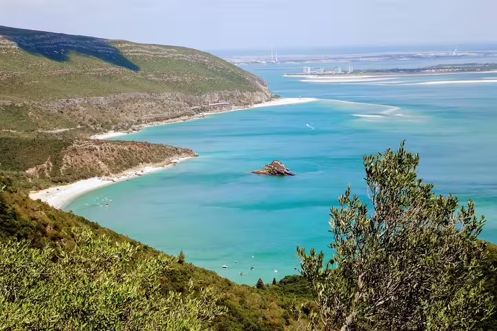 Scenic view of Arrábida Natural Park's coastline with turquoise waters and lush greenery on Lisbon's South Sights & Wine Tour.
