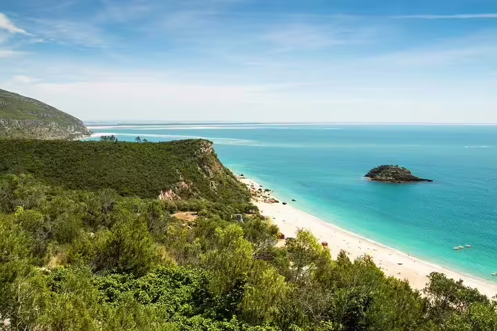 Scenic view of Arrabida coastline with turquoise waters and lush greenery, perfect for a private day tour from Lisbon.