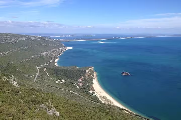 Scenic view of Arrabida coastline with azure waters and lush hills, perfect for a private tour with wine tasting in Setubal.