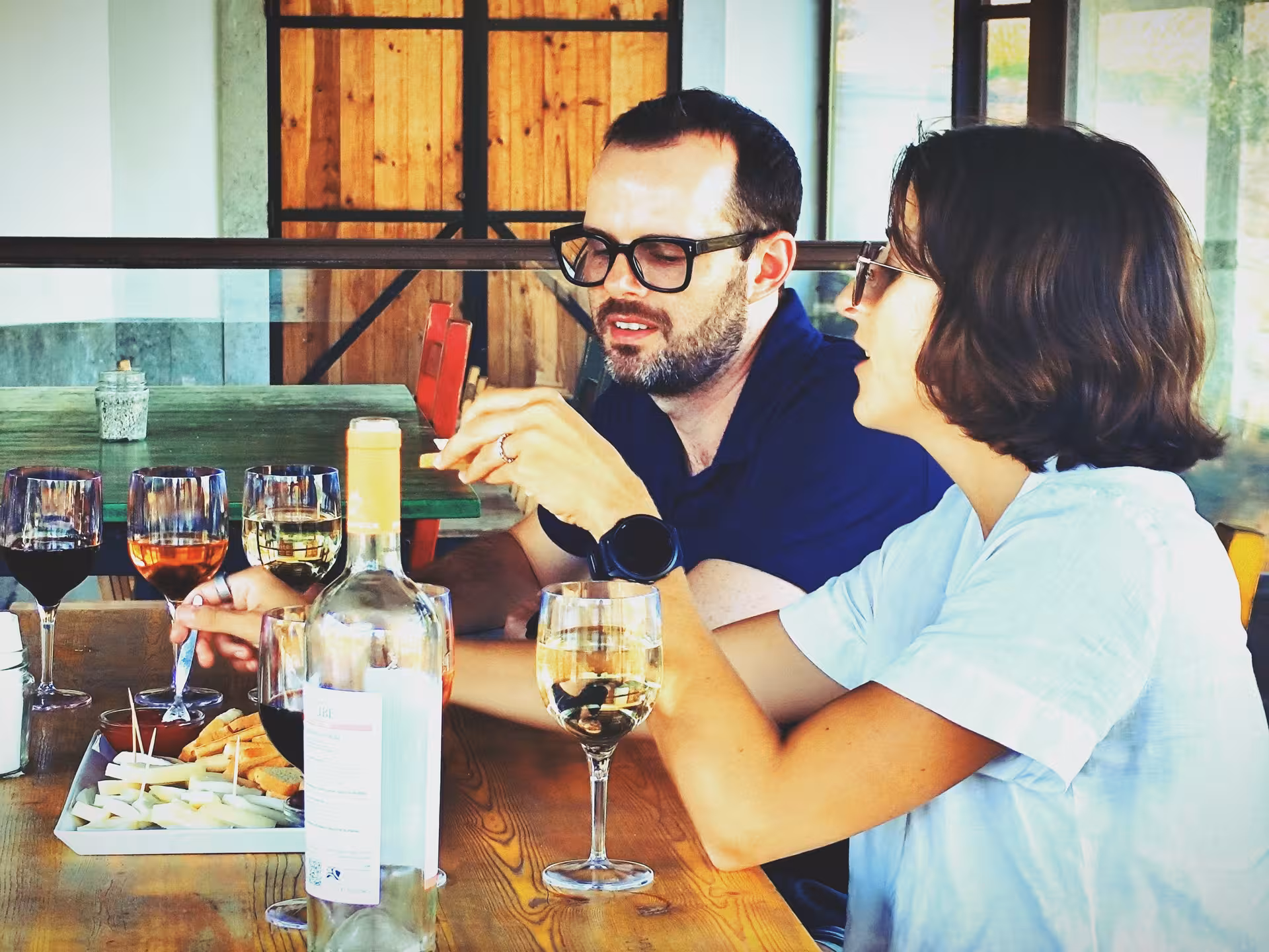 Couple tasting Portuguese wines with cheese and snacks during a private Arrábida wine tour food pairing