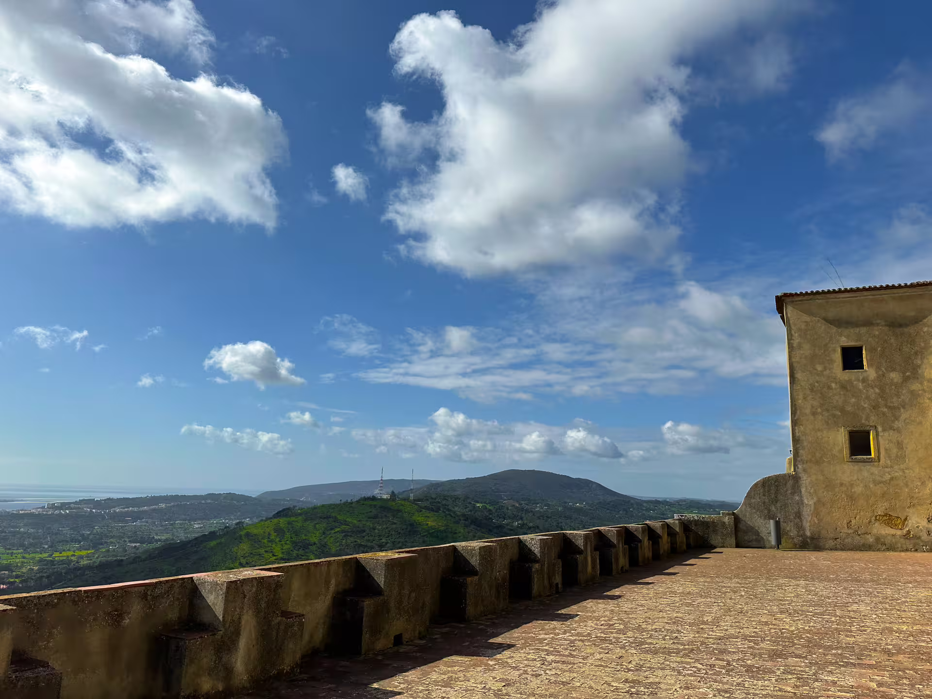 Scenic view from a historic fortress in Arrábida with lush hills and blue skies on the Setúbal tour.