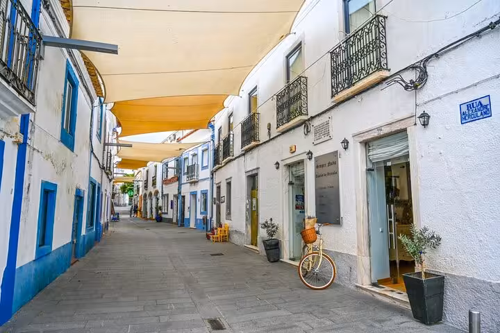 Charming street in Arraiolos with whitewashed buildings, balconies, and a bicycle, ideal for a private walking tour.