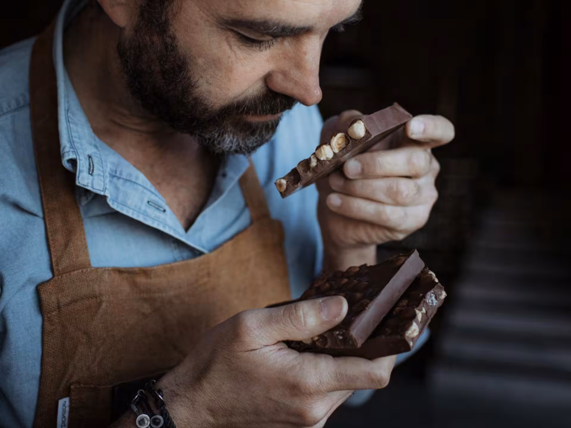 Man appreciating artisanal chocolate bars with nuts during a tasting session near Alessandria.