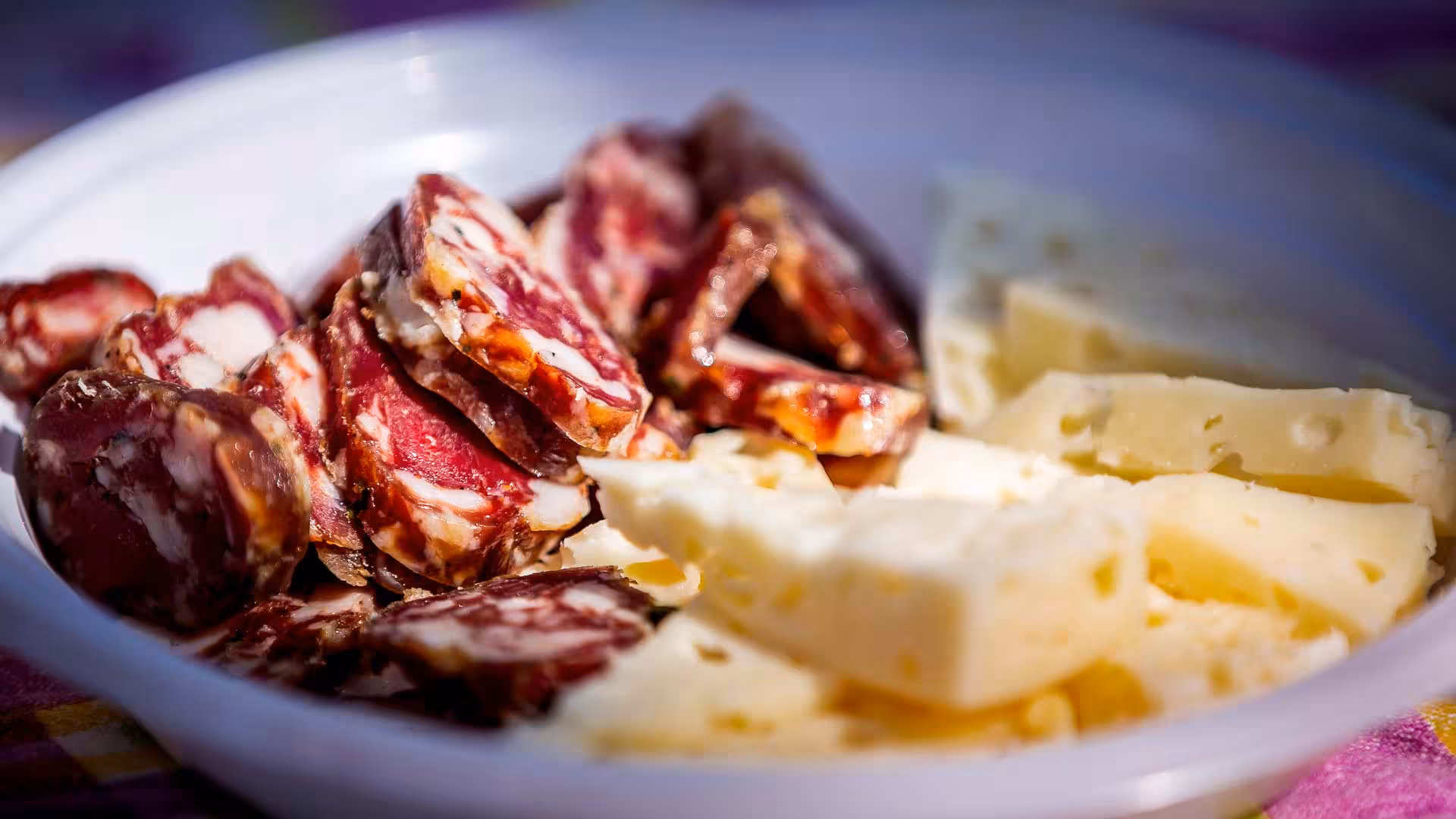 A platter of cured meats and cheeses, highlighting the traditional Sardinian tasting experience on the Arzana farm visit.
