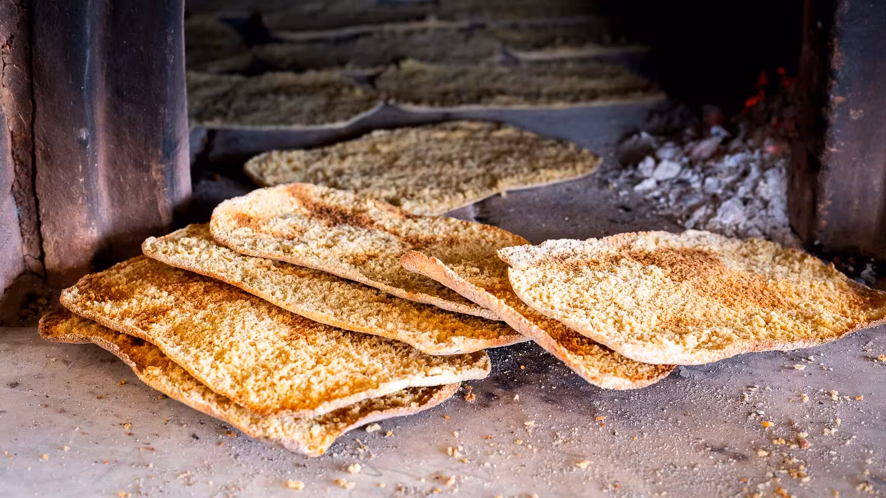Freshly baked Sardinian flatbread cooling in a rustic oven, part of the authentic Arzana farm culinary tour.