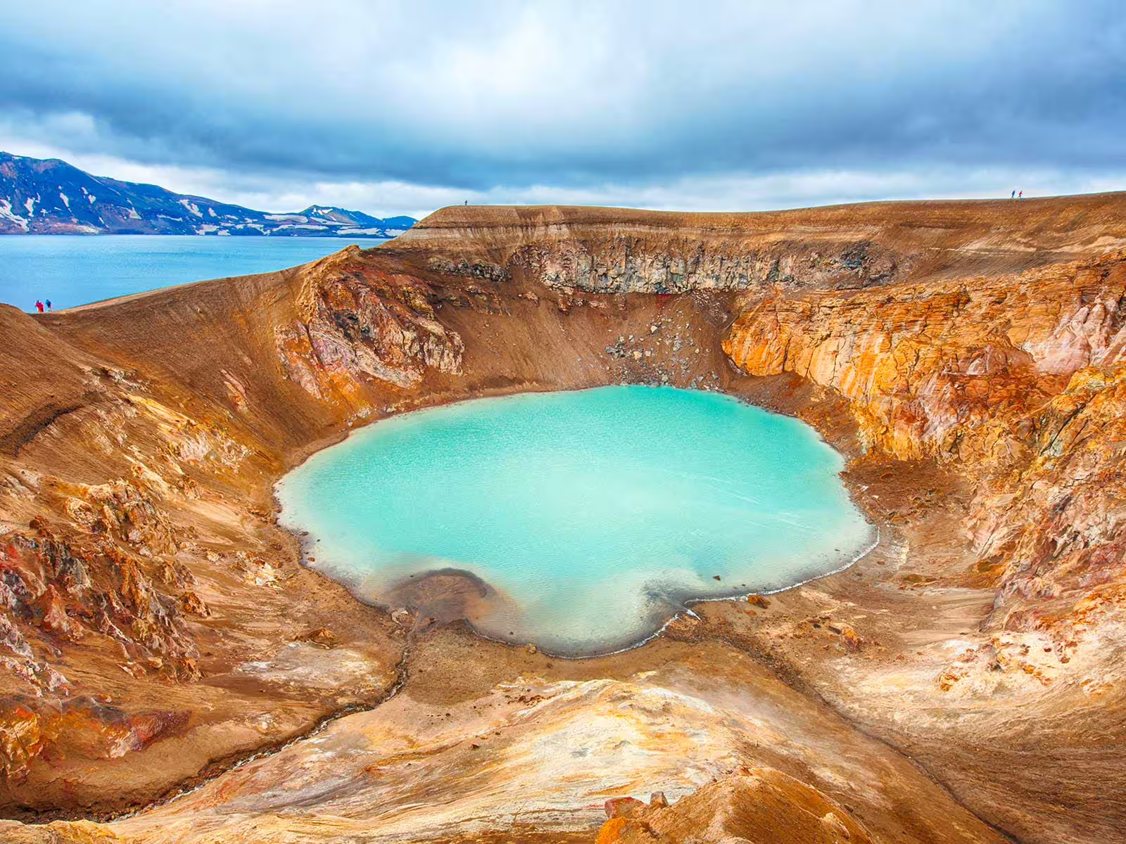 Turquoise geothermal crater lake inside Askja caldera with vast volcanic landscape and Öskjuvatn lake beyond