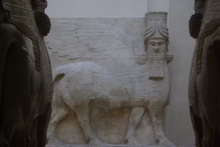 Ancient Assyrian lamassu winged bull sculpture with human head at the Louvre Museum Paris