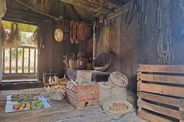Rustic ethnographic museum display of traditional Asturian farm goods in a wooden cabin.