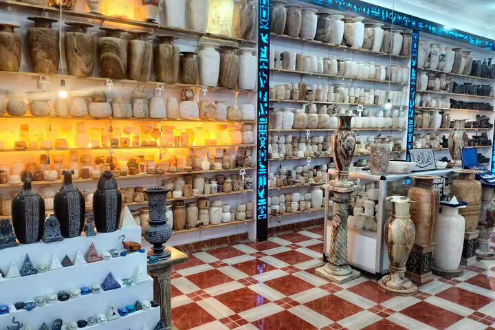 Aswan souvenir shop with ancient Egyptian alabaster jars and statues on 6-day Cairo Pyramids Felucca tour