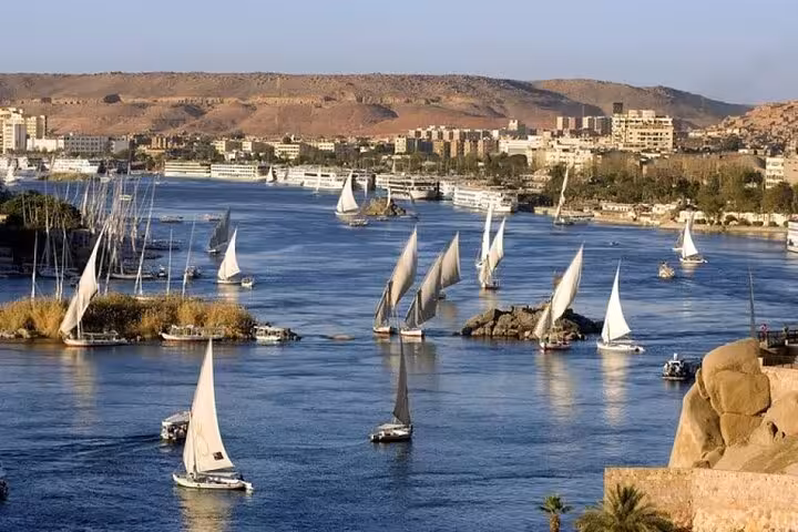 Panoramic Nile River in Aswan with multiple feluccas sailing, classic felucca cruise tour view