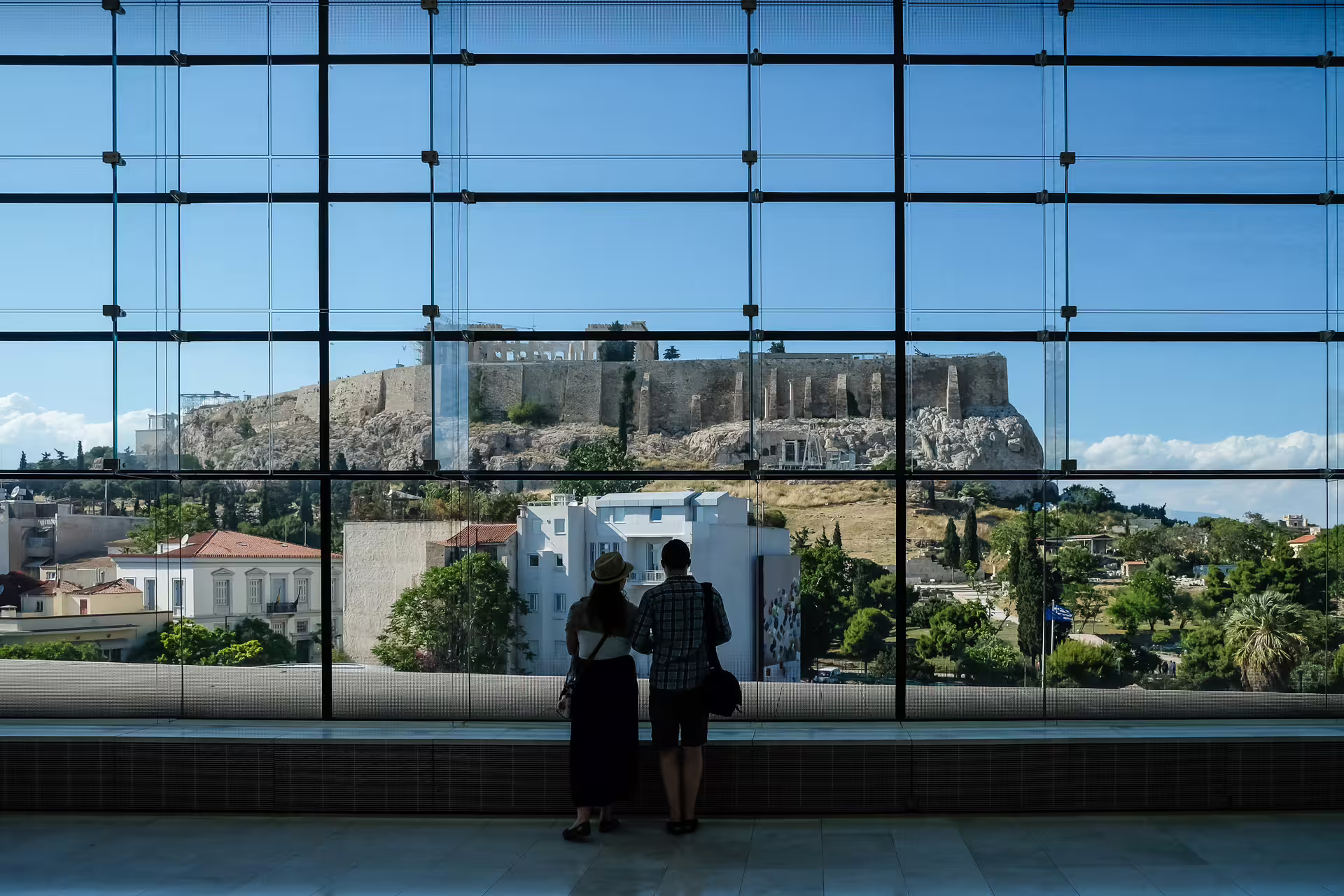 Visitors admire the Acropolis from the Acropolis Museum on an Athens small group tour with tickets included