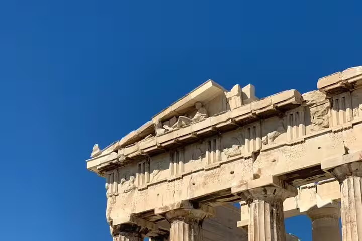 Parthenon pediment and frieze detail against blue sky on Athens Acropolis tour, paired with museum visit and lunch