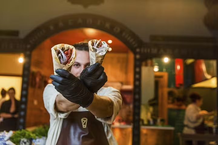 Chef holding fresh Greek souvlaki wraps for included lunch on Athens small group Acropolis, Parthenon and museum tour