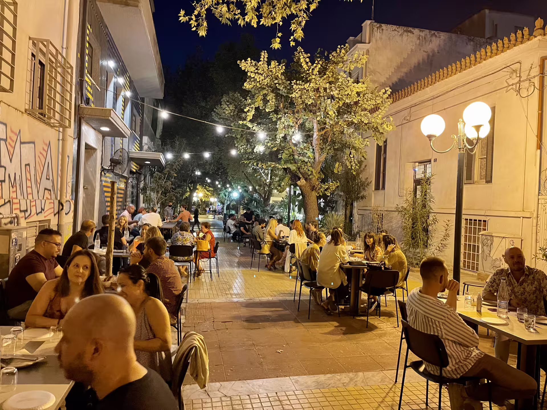 Nighttime Athens street dining near Piraeus, ideal stop after private transfer from Athens Airport to port