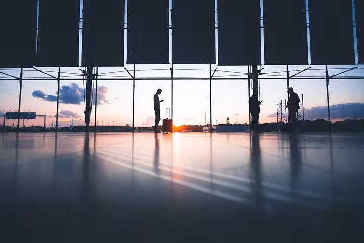 Athens airport terminal at sunrise with travelers, ideal for Athens hotel to airport private luxury transfer