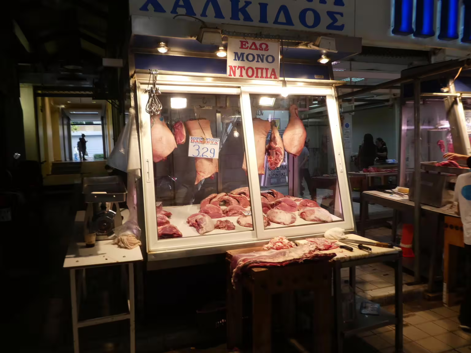 Butcher stall at Athens Central Market with fresh cuts on display, authentic stop on a gourmet food tour