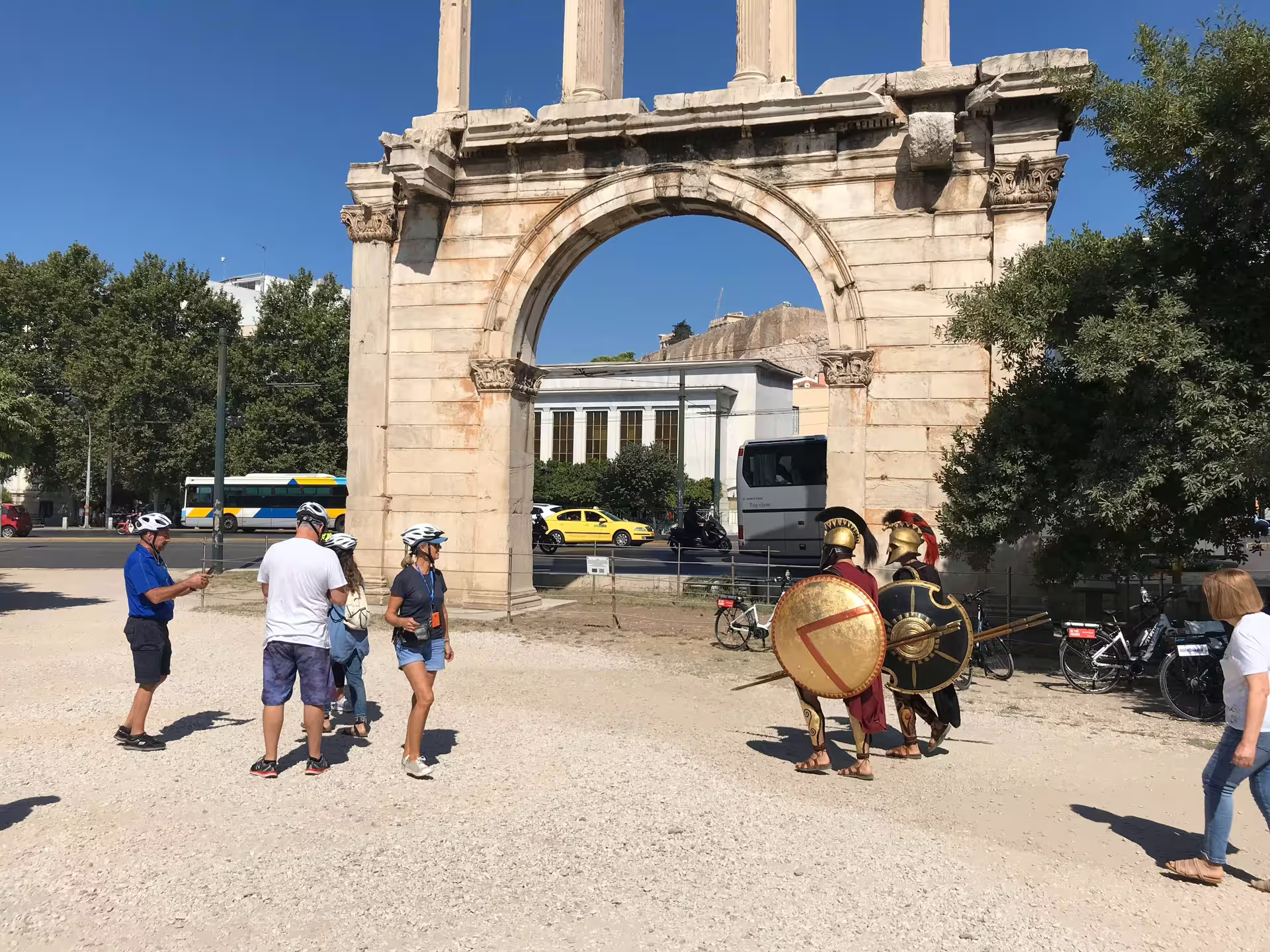 Tourists in front of Hadrian's Arch during an Athens e-bike tour, capturing historical charm and Greek culture.