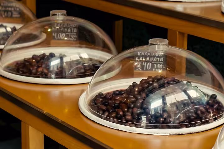 Greek kalamata olives under glass domes at Athens market stop on Small Group Athens Walk and Taste tour