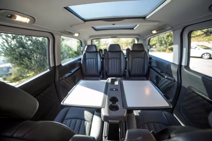 Executive van interior with table seating for Athens airport to Lavrio port private transfer, ideal for groups