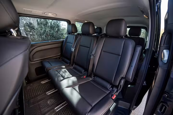 Rear leather seats in private van for Athens hotel to Lavrio port transfer, comfortable ride with ample legroom