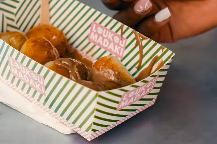 Close-up of loukoumades drizzled with chocolate on Athens food tour, sweet tasting on small group walk