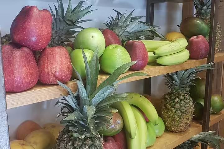 Fresh fruit display of apples, bananas and pineapples at Athens market, a highlight of the food tour