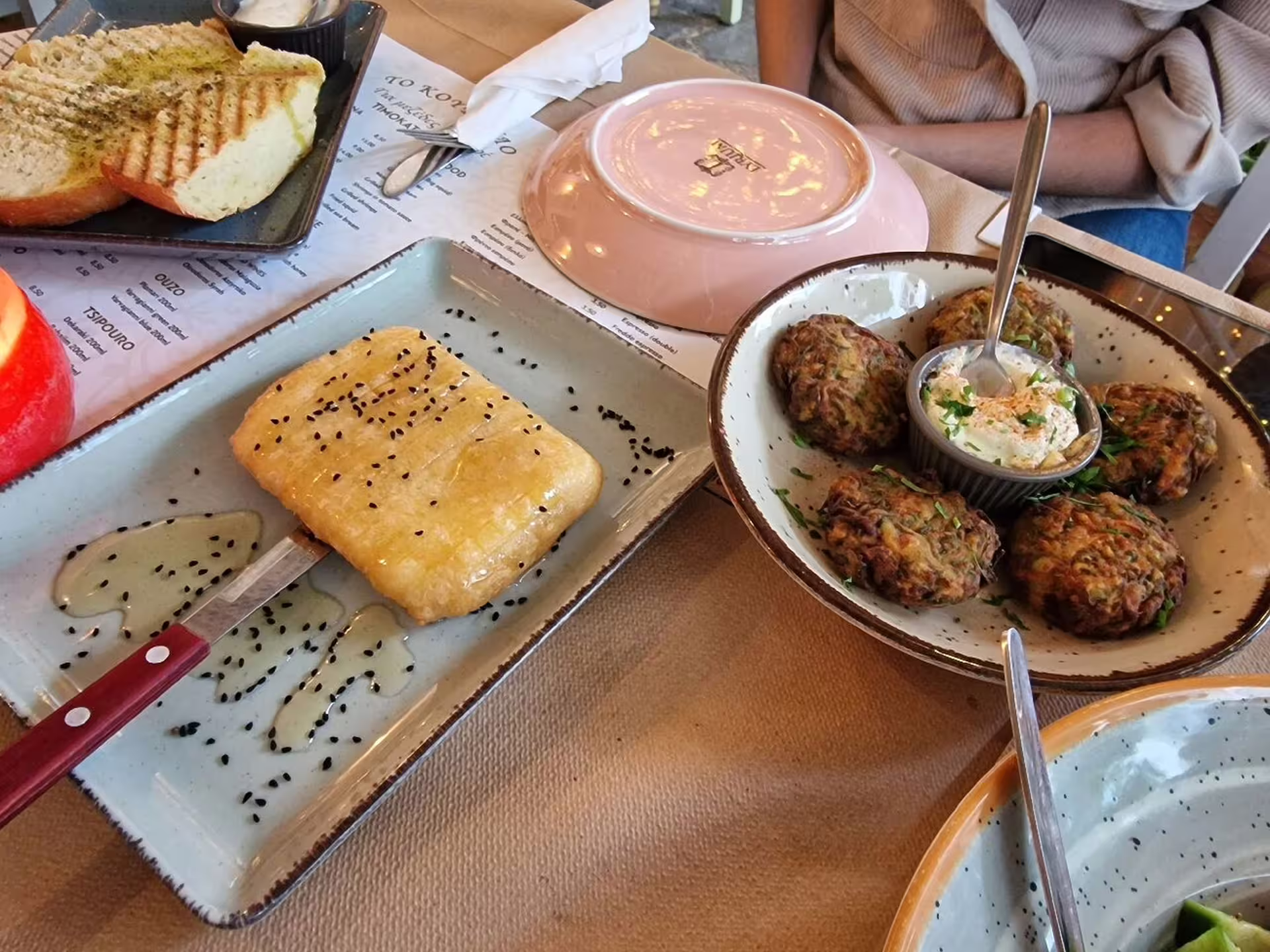 Greek meze dinner on Athens night walking tour, featuring grilled bread, zucchini fritters and dip