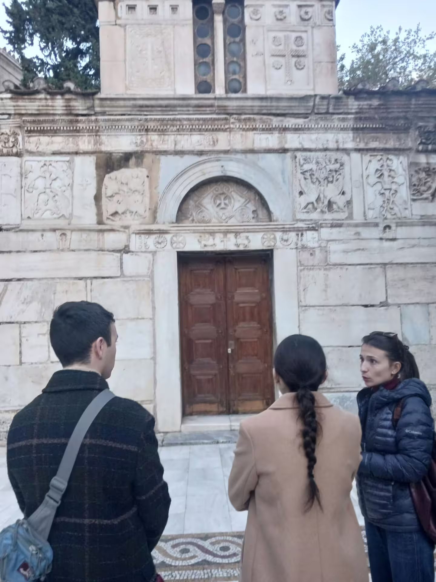 Small-group Athens walking tour guide explaining historic church facade, part of an evening tour with Greek dinner
