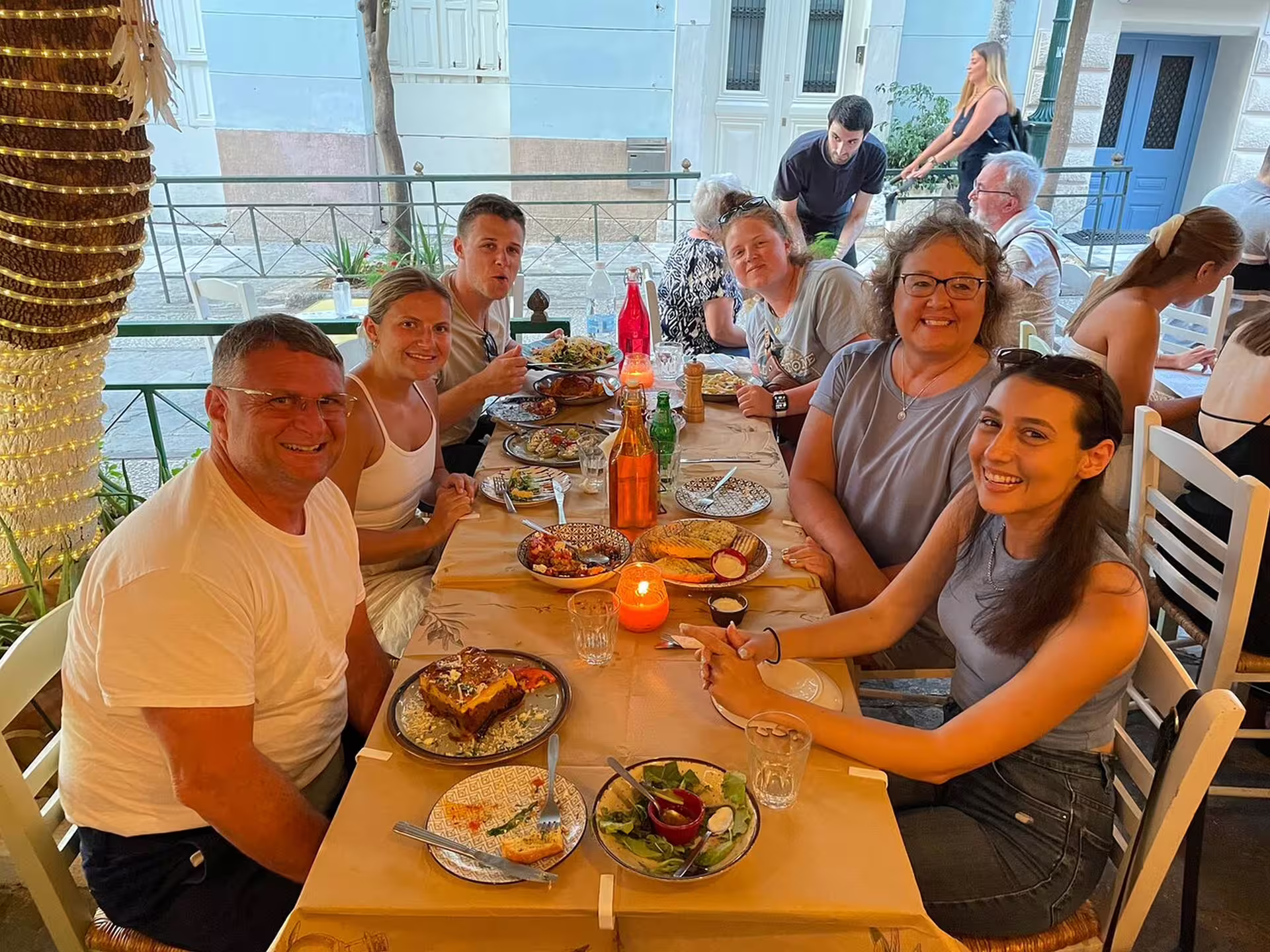 Small-group Athens at night walking tour dinner with travelers sharing Greek dishes at a local taverna