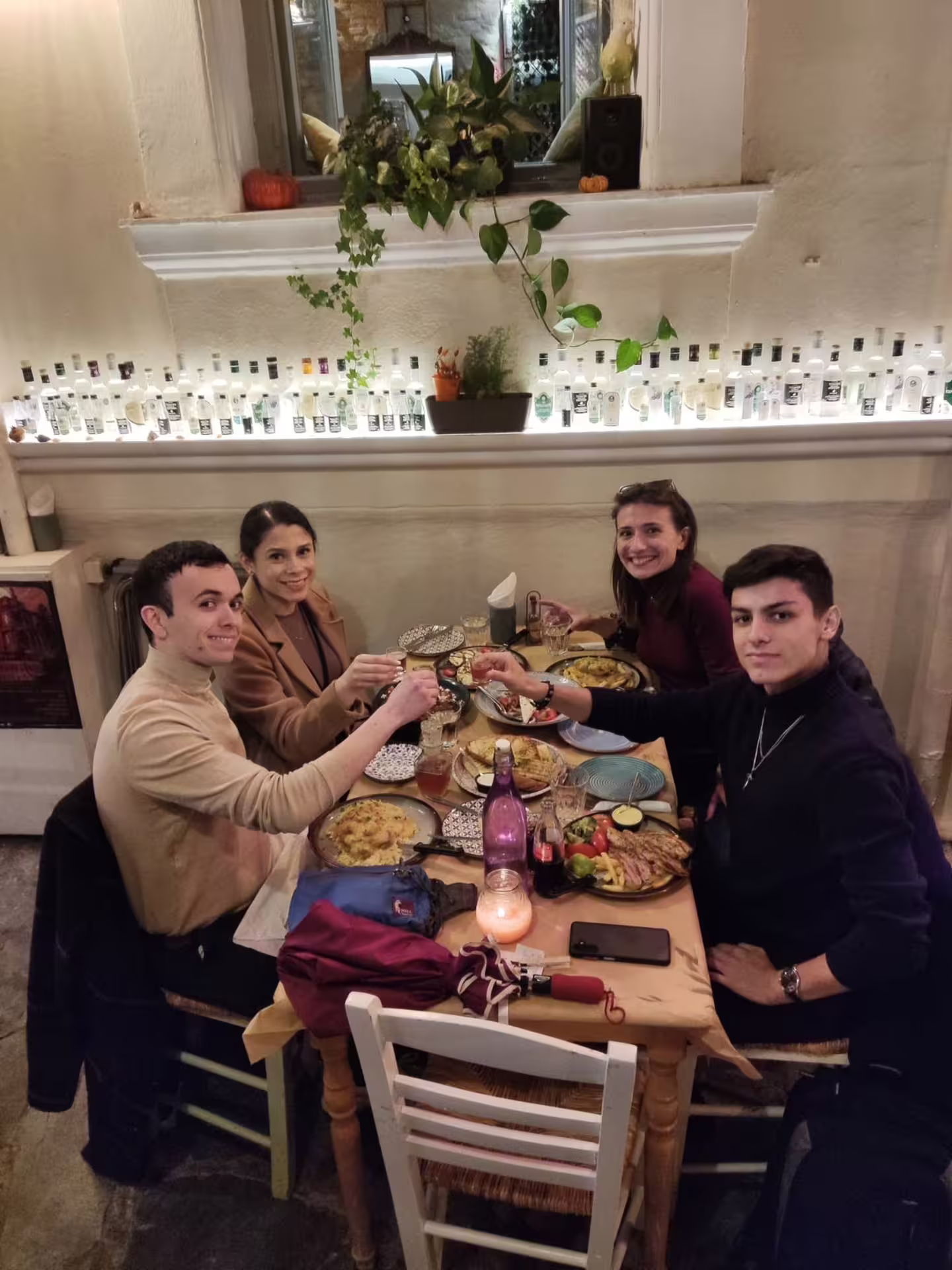 Friends enjoy Greek dinner at a cozy taverna on the Athens at Night small-group walking tour