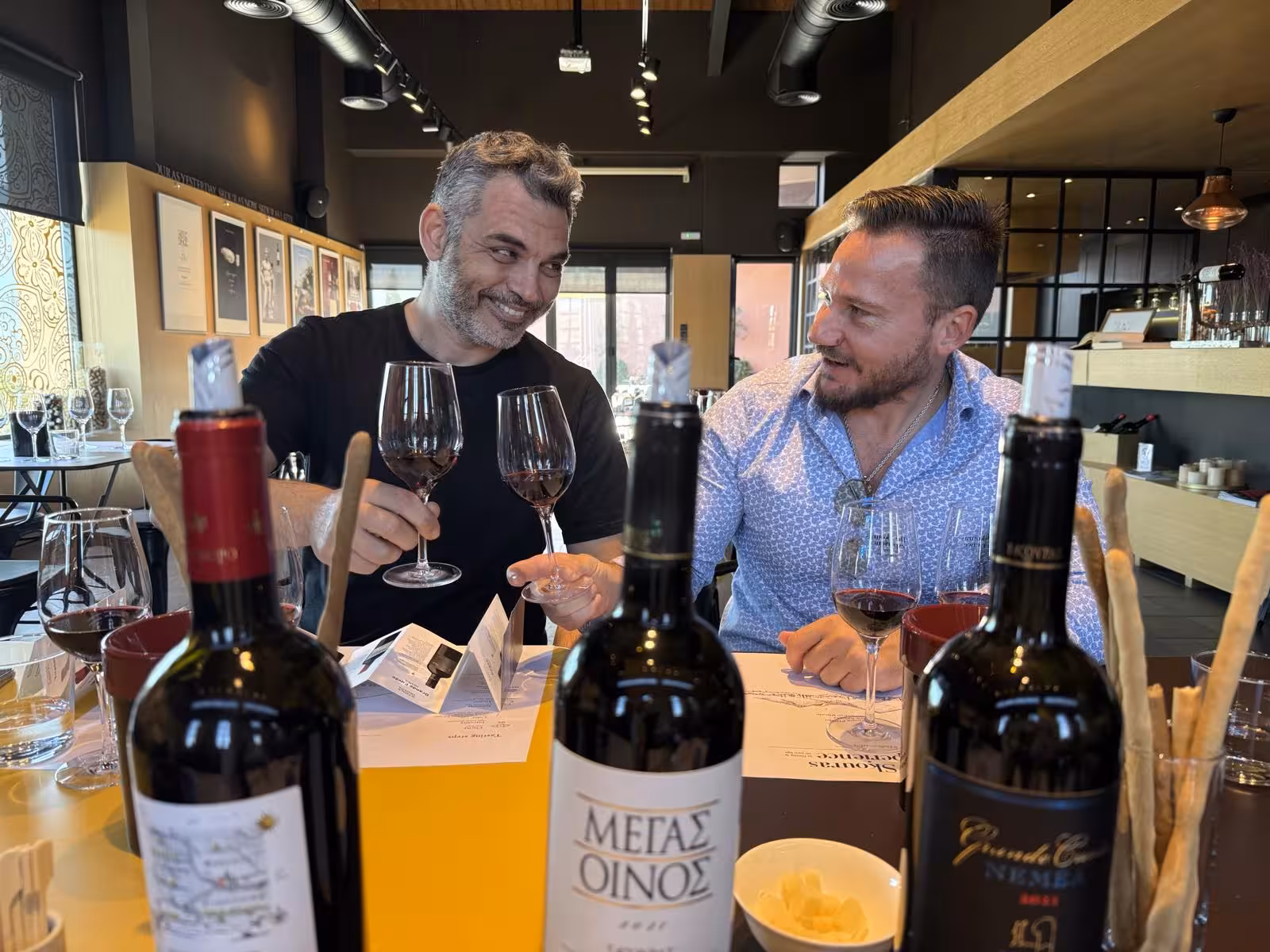 Guests sample Greek red wines at a stylish Athens wine bar on a guided night walking and wine tasting experience