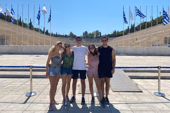 Visitors posing at the historic Panathenaic Stadium, a highlight of the Athens full-day private shore excursion.