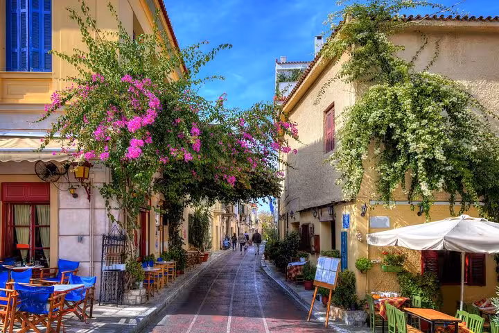 Plaka neighborhood street with cafes and bougainvillea, featured on Athens airport transfer city highlights