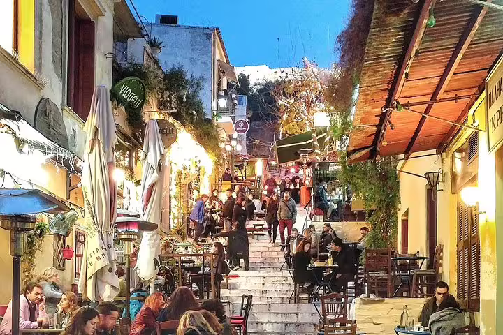 Evening in Athens Plaka with lively tavernas and stairs, part of a private walking tour with Acropolis tickets