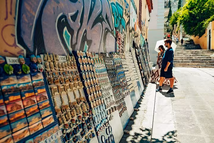 Tourists browse souvenir stalls in Plaka, Athens, on a small group walking tour with local guide