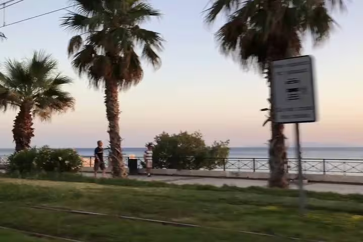 Palm-lined Athens Riviera seaside promenade at dusk, en route to Cape Sounion sunset private tour