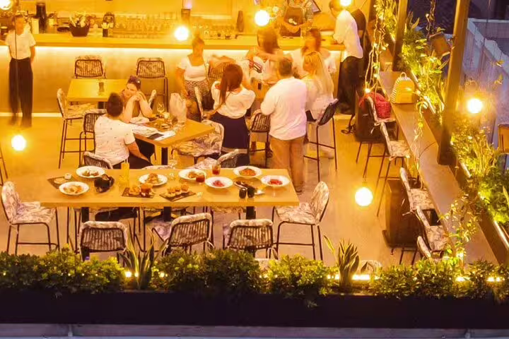 Rooftop dining terrace in Athens for Greek cooking class dinner, warm lights and shared meze plates