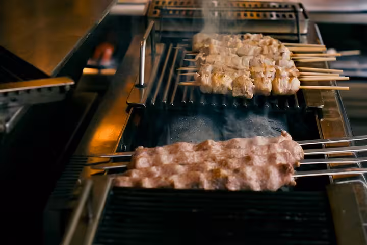 Grilling Greek souvlaki skewers during Small Group Athens Walk and Taste street food tour