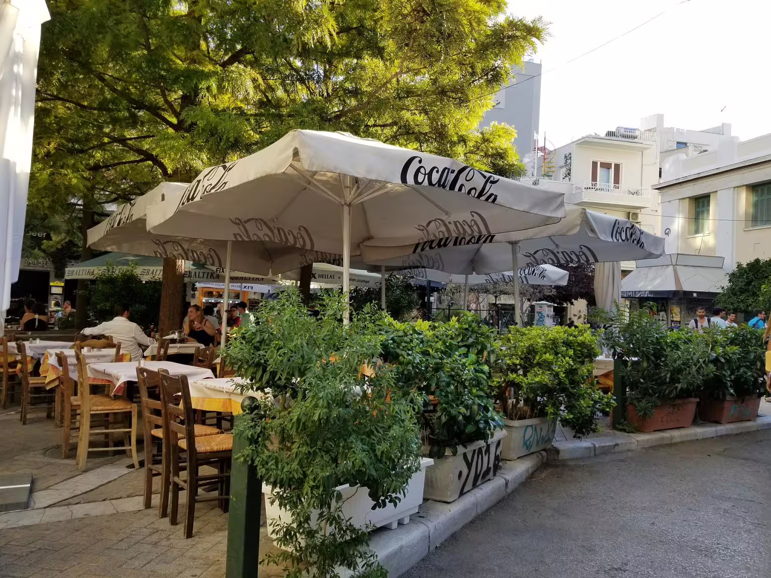 Outdoor taverna in Athens with shaded tables, ideal stop on a gourmet food walking tour in Plaka