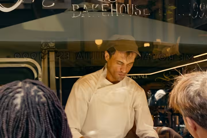 Local chef serving street food to visitors on a small-group Athens Walk and Taste culinary tour