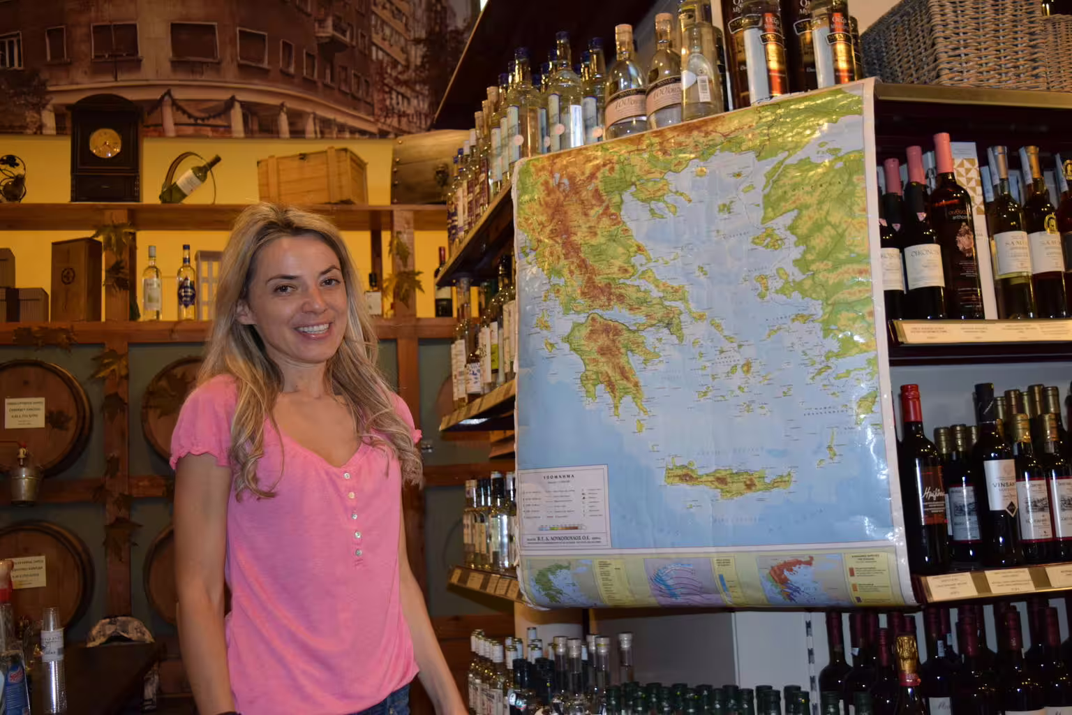 Greek wine shop tasting stop in Athens, guide by map with bottles of ouzo and local wines on food tour