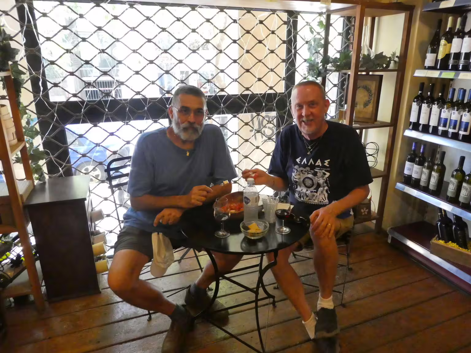 Wine tasting with meze in an Athens wine shop during a gourmet food walking tour, sampling local Greek flavors