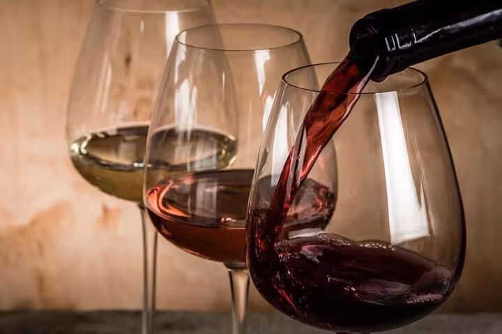 Close-up of red wine being poured into glasses during a private Athens wine tasting with wine guide