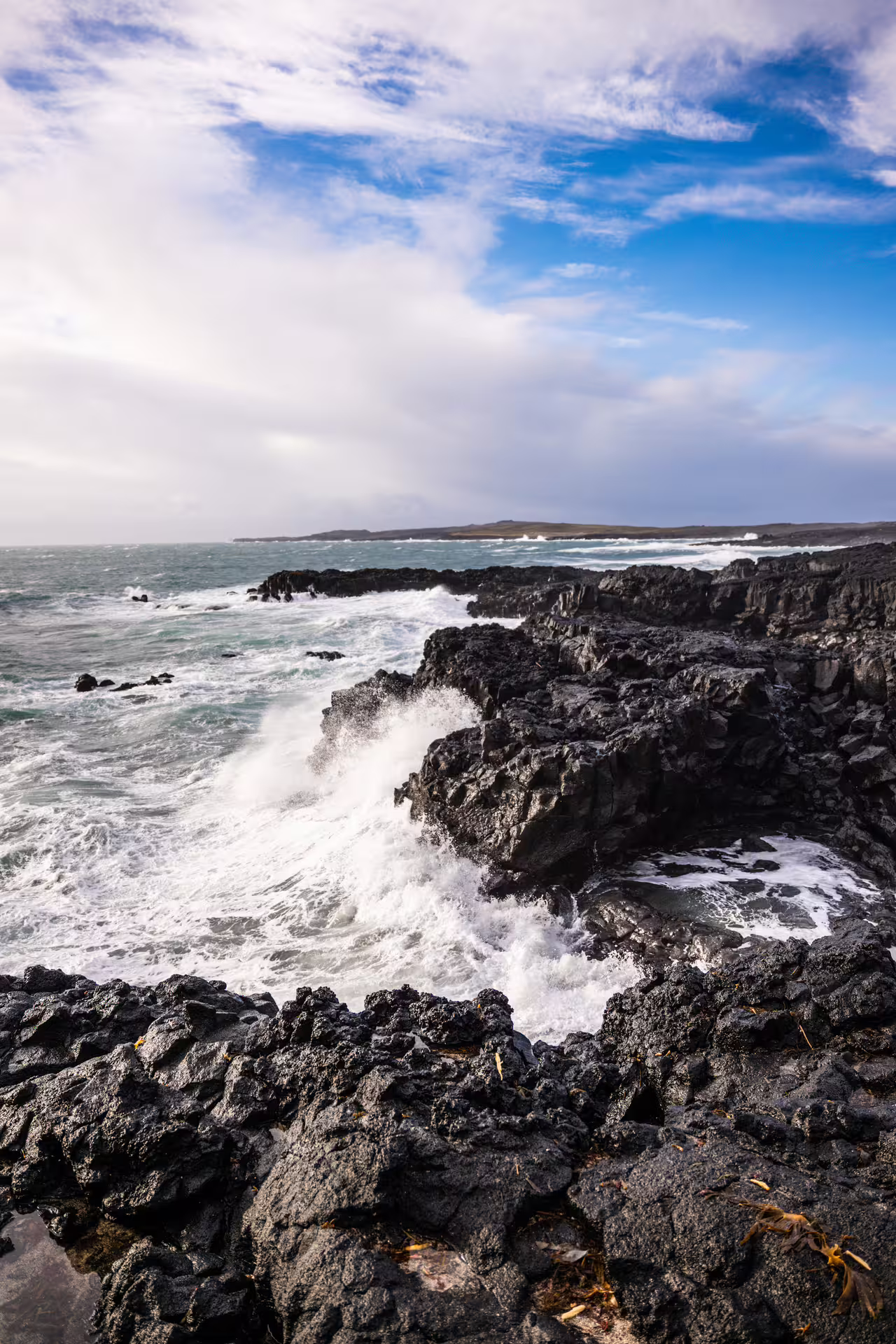 Powerful Atlantic waves crashing against black lava rock cliffs on the scenic Reykjanes Peninsula Iceland photography tour