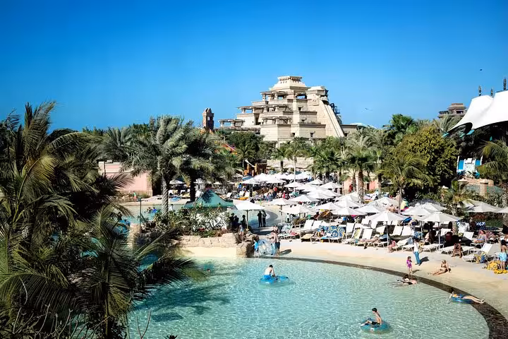 Lazy river and pool area at Atlantis Aquaventure Dubai day pass with palm trees and sun loungers